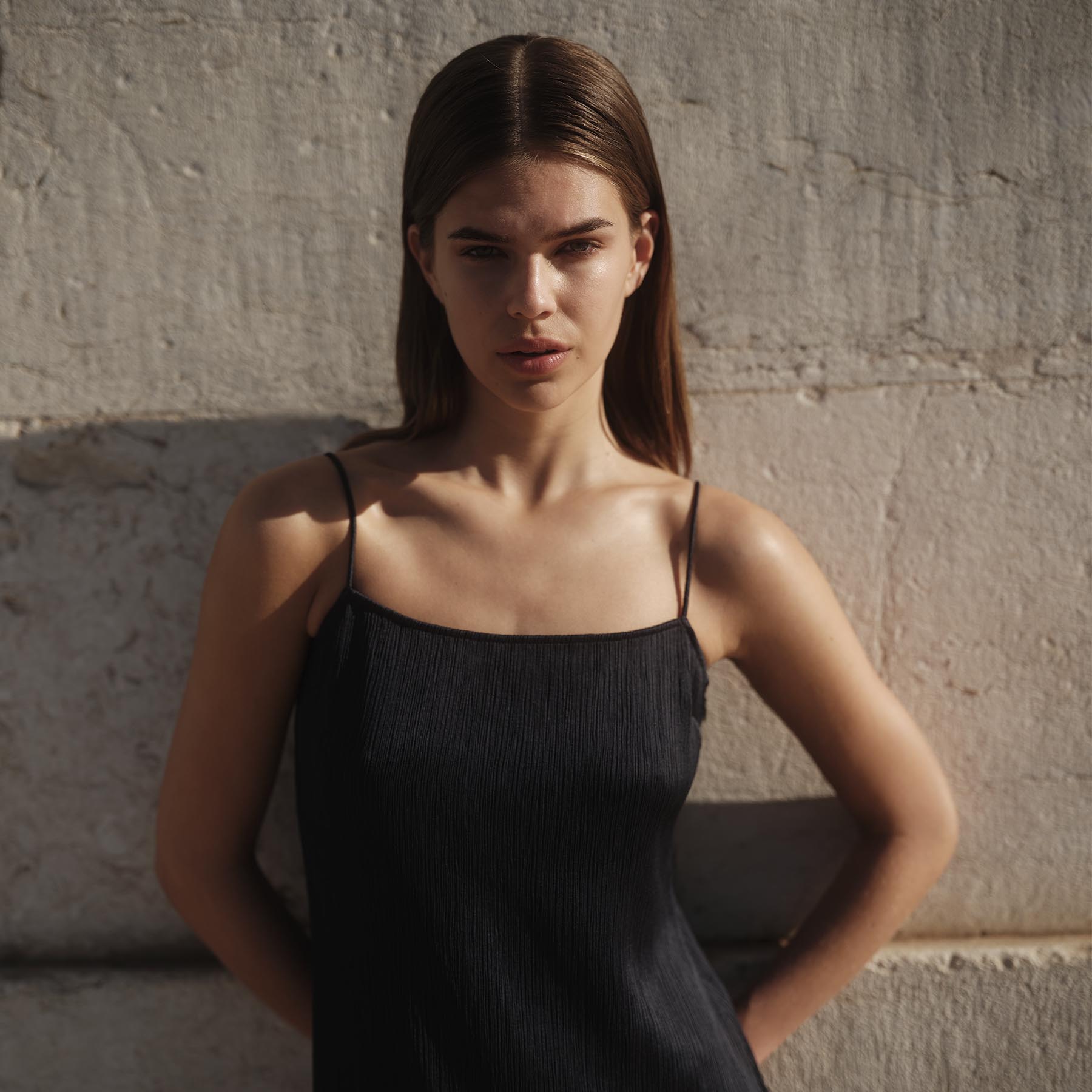 Femme portant une robe noire à bretelles.