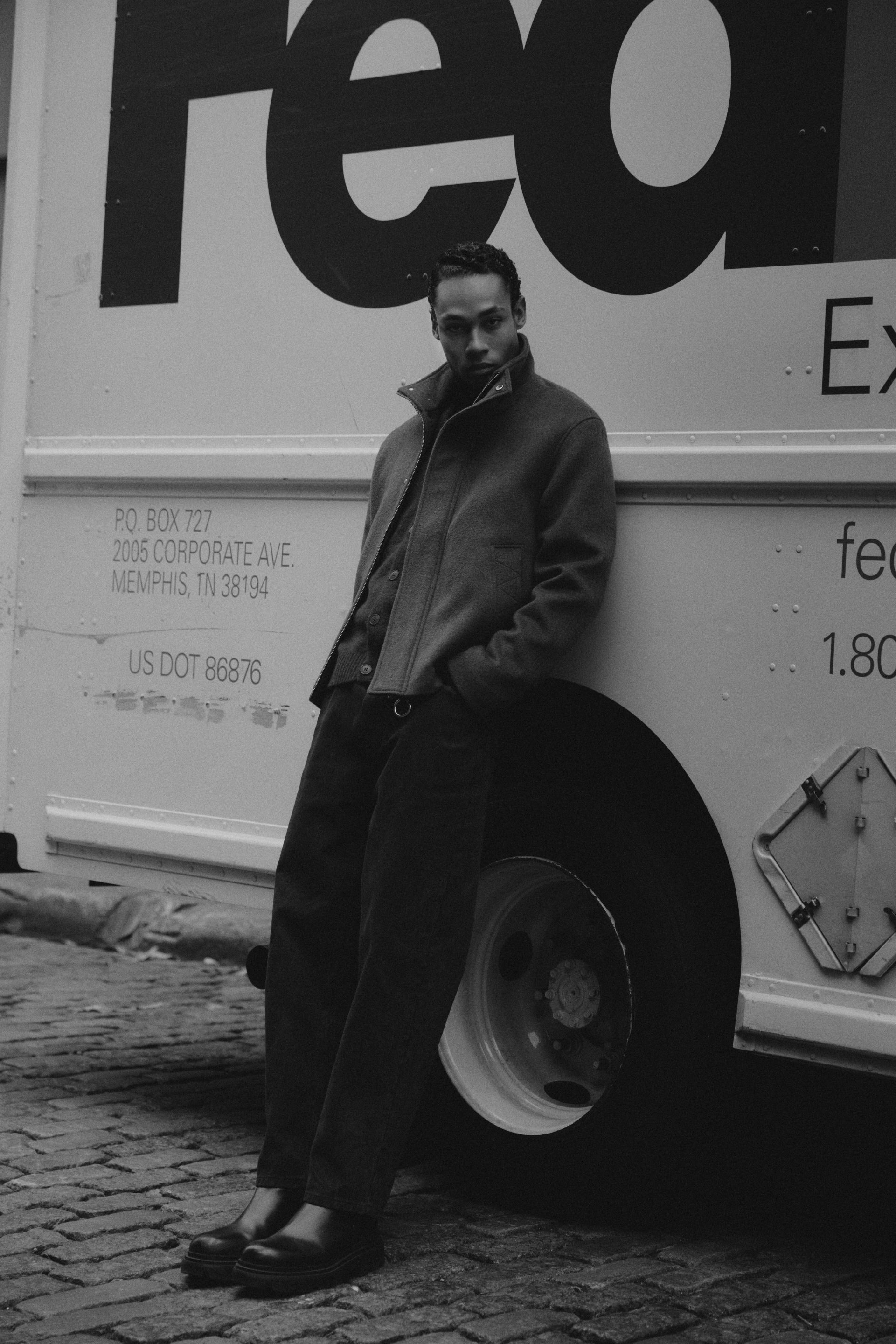 Homme en veste en laine verte à New York, en noir et blanc.